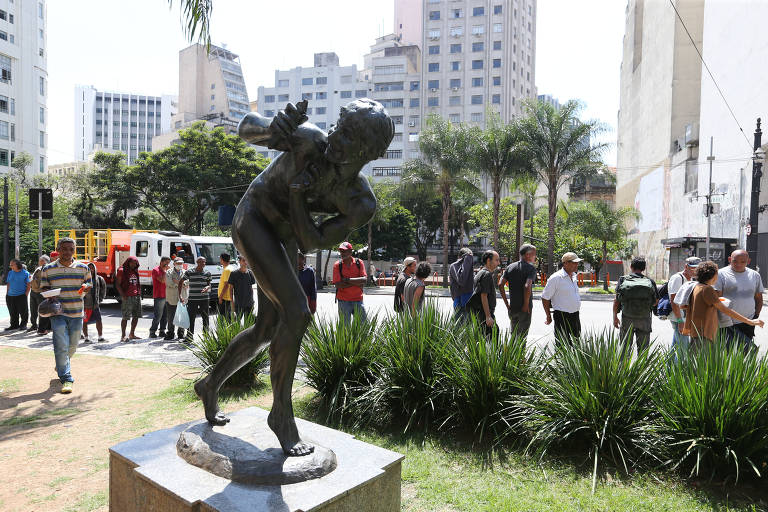 Moradores de rua fazem fila para receber comida distribuída por padres franciscanos, em frente ao largo de São Francisco, no centro de SP
