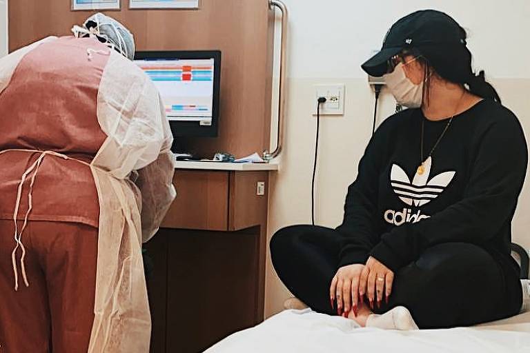 mulher com máscara em uma cama do hospital
