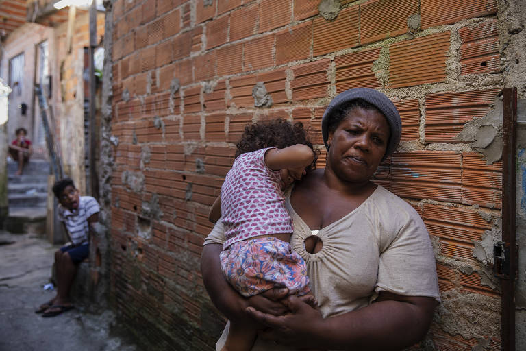 Regina Marcondes,48, em uma viela na favela do Gato Preto, na Brasilândia, zona norte de São Paulo