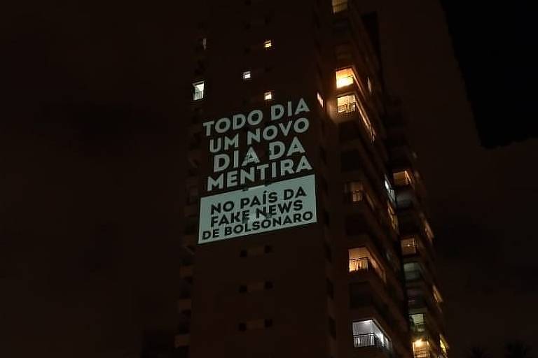 Projeção em prédio com os dizeres "Todo dia um novo dia da mentira no país da fake news de Bolsonaro"