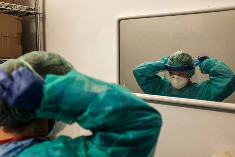 Enfermeira se veste para tratar pacientes de coronavírus