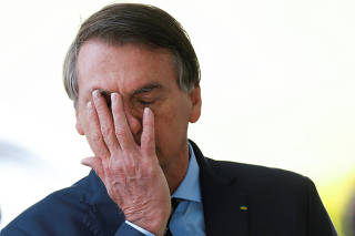 Brazil's President Jair Bolsonaro reacts while meeting supporters as he leaves Alvorada Palace, amid the coronavirus disease (COVID-19) outbreak, in Brasilia
