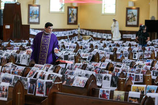 Catholic priest Manzotti conducts a mass, broadcast live on television, with photos of the faithful over the church's banks during the coronavirus disease (COVID-19) outbreak in Curitiba
