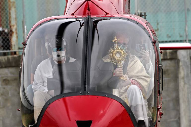 Bispo-auxiliar de Guayaquil (Equador), Giovanni Battista Piccioli (dir.) usa máscara de proteção enquanto abençoa a cidade