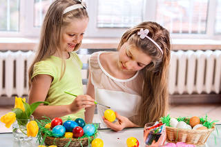 Children paint Easter eggs at home.