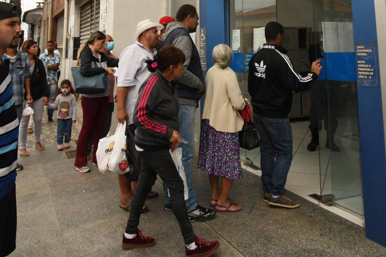 Moradores de Itapecerica da Serra (SP), que teve maior isolamento do estado no domingo (12), se aglomeram em banco