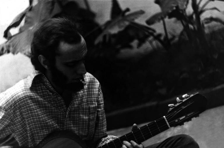 O compositor Aldir Blanc tocando violão