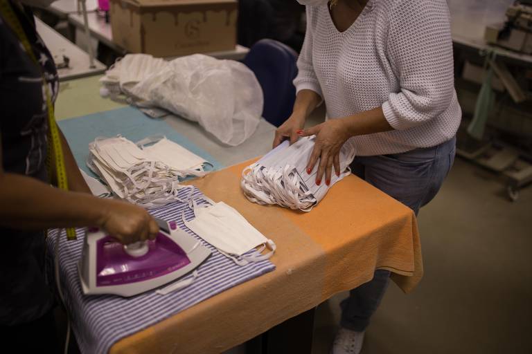 Moradores e voluntários da favela do Paraisópolis se unem para preparar máscaras que são distribuídas aos moradores da região