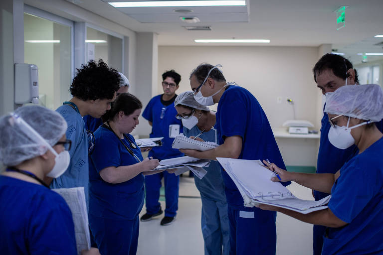 Médicos do Instituto de Infectologia Emílio Ribas observam dados de pacientes que estão na UTI com coronavírus