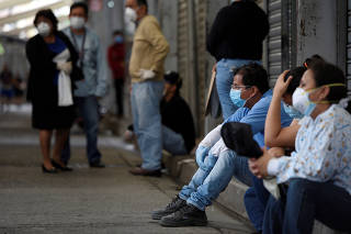 People wait outside a government clinic as health and funeral services have been overwhelmed amid the outbreak of the coronavirus disease (COVID-19) in Guayaquil