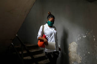 A Cuban doctor walks down a flight of stairs during an inspection round at the slum of Lidice during the nationwide quarantine due to the coronavirus disease (COVID-19) outbreak in Caracas