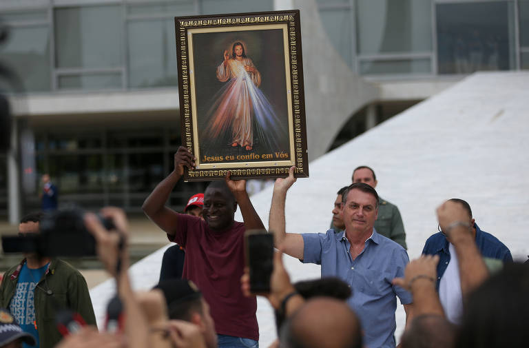 O presidente Jair Bolsonaro acena e conversa com apoiadores na rampa do Palácio do Planalto; manifestantes que participavam de uma carreata contra o aborto saudaram o presidente