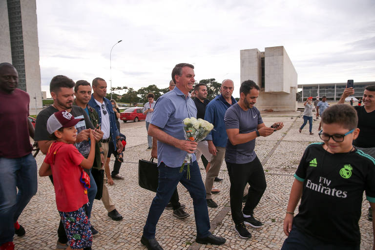 O presidente Jair Bolsonaro conversa e tira fotos com apoiadores na praça dos Três Poderes