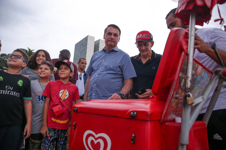 O presidente Jair Bolsonaro compra um picolé de um vendedor ambulante, na praça dos Três Poderes