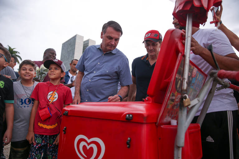 O presidente Jair Bolsonaro compra um picolé de um vendedor ambulante, na praça dos Três Poderes