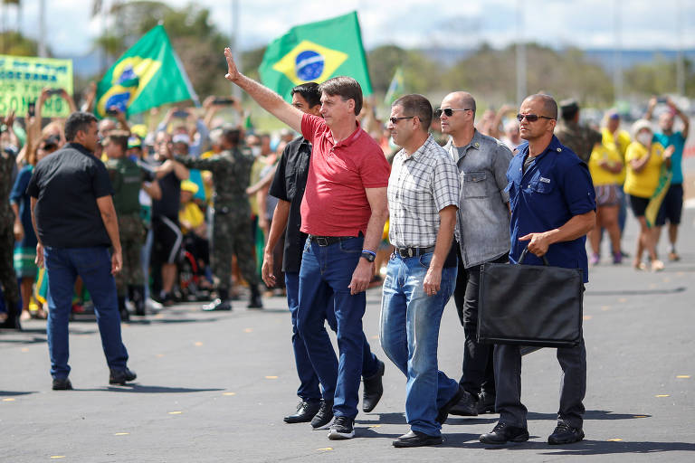 O presidente Jair Bolsonaro se encontra com apoiadores que participavam de uma carreata em apoio ao governo e contra as medidas de isolamento, diante do quartel-general do Exército, em Brasília, neste domingo (19)