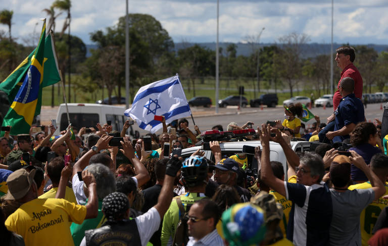 O presidente Jair Bolsonaro se encontra com apoiadores que participavam de uma carreata em apoio ao governo e contra as medidas de isolamento, diante do quartel-general do Exército, em Brasília, neste domingo (19)