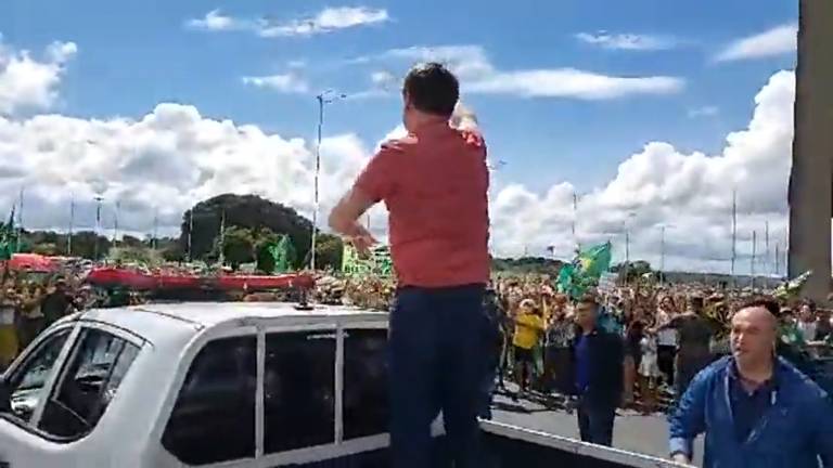 O presidente Jair Bolsonaro acena para manifestantes em frente ao QG do Exército, em Brasília