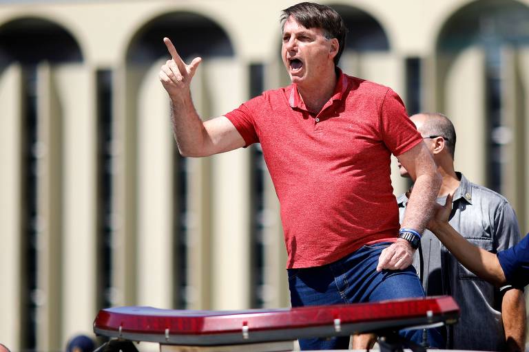 O presidente Jair Bolsonaro se encontra com apoiadores que participavam de uma carreata em apoio ao governo e contra as medidas de isolamento, diante do quartel-general do Exército, em Brasília, neste domingo (19)