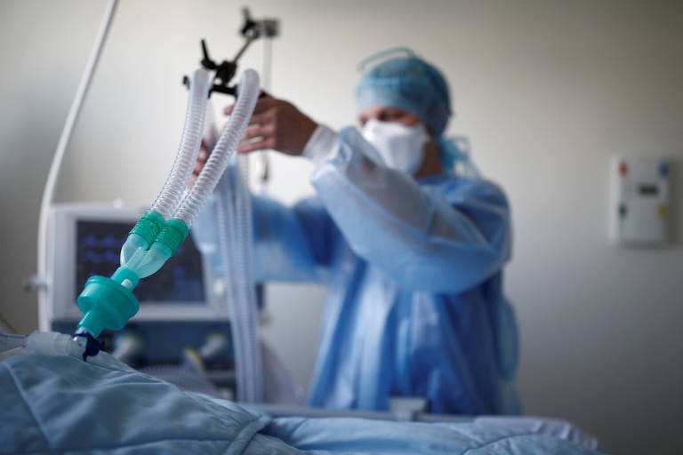 Enfermeira checa respirador em paciente em hospital perto de Paris, na França