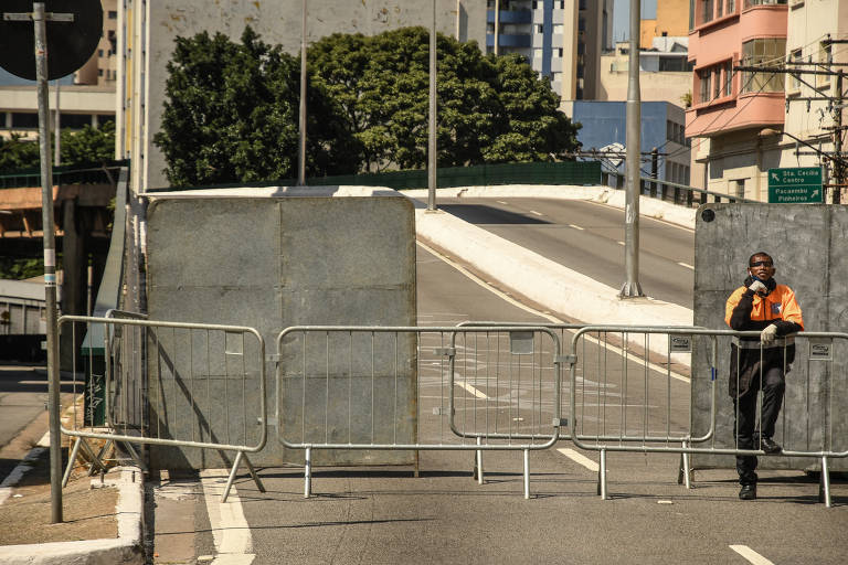 O segurança Edinilson Ferreira, 39, atrás das cercas que impedem o acesso de pedestres e ciclistas ao Minhocão durante a quarentena