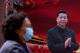 FILE PHOTO: Woman wearing a protective mask is seen past a portrait of Chinese President Xi on a street as the country is hit by an outbreak of the coronavirus, in Shanghai