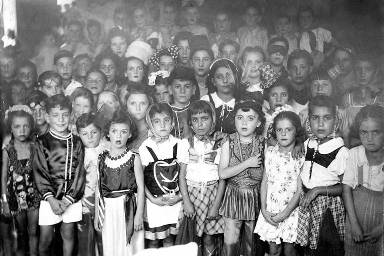 O escritor Raduan Nassar em sua infância (o segundo menino, a partir da esq., na primeira fileira) e Doraliza de Filippi 
(ao centro, de boina branca grande) em baile de Carnaval em Pindorama (SP), no início dos anos 1940