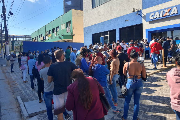 Cerca de 200 pessoas esperavam em fila para sacar auxílio emergencial na agência da Caixa da avenida Sapopemba número 13.446, em São Mateus (zona leste da capital), na manhã desta segunda (27)
