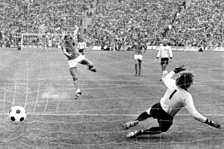 O holandês Neeskens chuta a bola no meio do gol para superar o alemão Sepp Maier, que pulou para a direita, e marcar de pênalti gol na final da Copa do Mundo de 1974