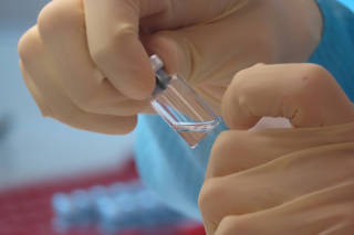 A scientist cleans vaccine vials at the Clinical Biomanufacturing Facility (CBF) in Oxford