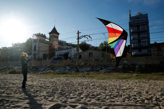 A boy flies a kite on a beach, after restrictions were partially lifted for children, following the coronavirus disease (COVID-19) outbreak in El Masnou