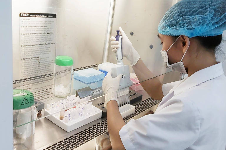 Funcionária do laboratório Viet A Corp, no Vietnã, trabalha em teste de coronavírus