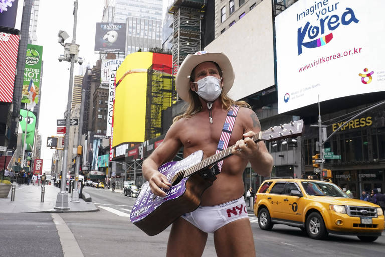 Robert Burck, conhecido como o Naked Cowboy posa para fotos em Times Square, em Nova York