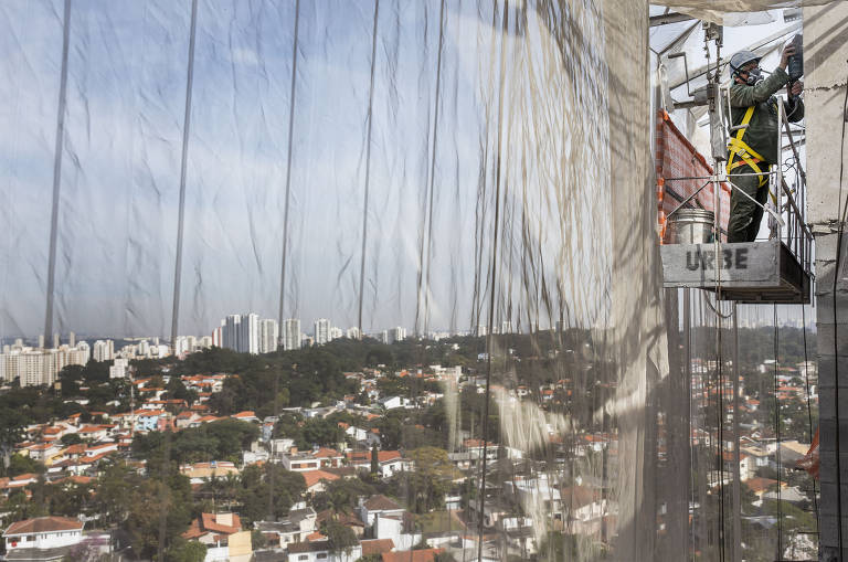 Obras continuam mesmo durante período de quarentena; usando  máscara, operários de construção civil trabalham em uma obra no bairro Cidade Ademar, em São Paulo
