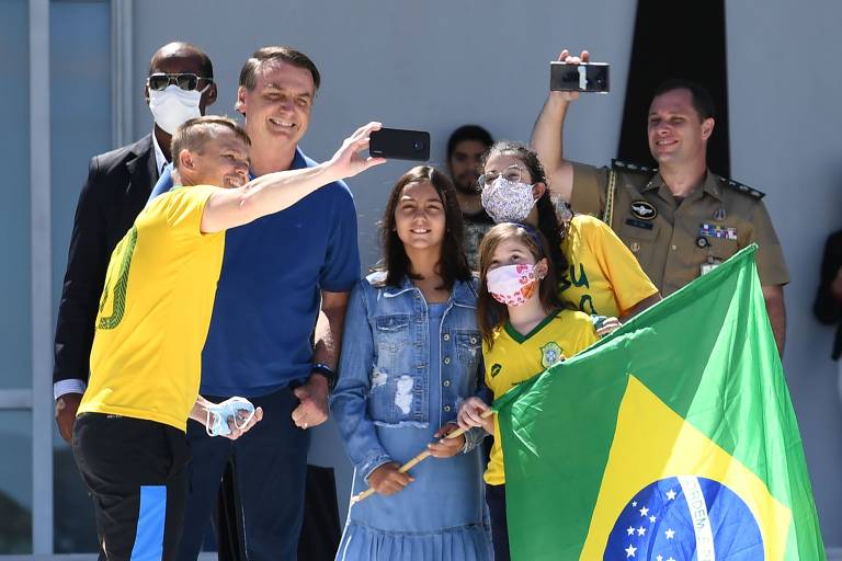 O presidente Jair Bolsonaro posa para uma selfie com apoiadores durante ato em Brasília