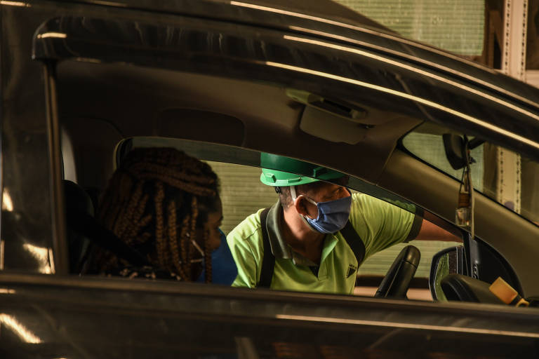 Lojas e shoppings fazendo drive-thru; Funcionário orienta um cliente na Leroy Merlin
