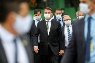 Brazil's President Jair Bolsonaro wearing a protective mask walks to the Planalto Palace after a meeting with President of Brazil's Supreme Federal Court Dias Toffoli, amid the coronavirus disease (COVID-19) outbreak in Brasilia
