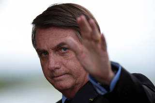 Brazil's President Jair Bolsonaro waves before a meeting with Brazil's Defence Minister Fernando Azevedo e Silva at the Ministry of Defence headquarters in Brasilia