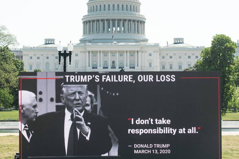 Cartaz colocado na frente do Capitólio critica o modo como o presidente Donald Trump lida com a pandemia de coronavírus 