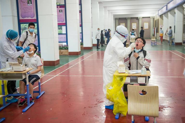 Estudantes chineses passam por teste para Covid-19 na volta às aulas em Wuhan; veja fotos de hoje