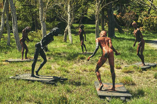 Eric Fischl?s life-size sculptures of nymphs, titled ?Young Dancers Dancing,? amid a grove of trees at his home in Sag Harbor, N.Y., on Long Island, as part of the ?Drive-by-Art (Public Art in This Moment of Social Distancing)? exhibition, May 10, 2020. (Bryan Derballa/The New York Times)