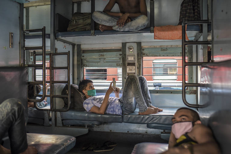 Trabalhadores a bordo de um trem com destino a cidades no estado de Uttar Pradesh