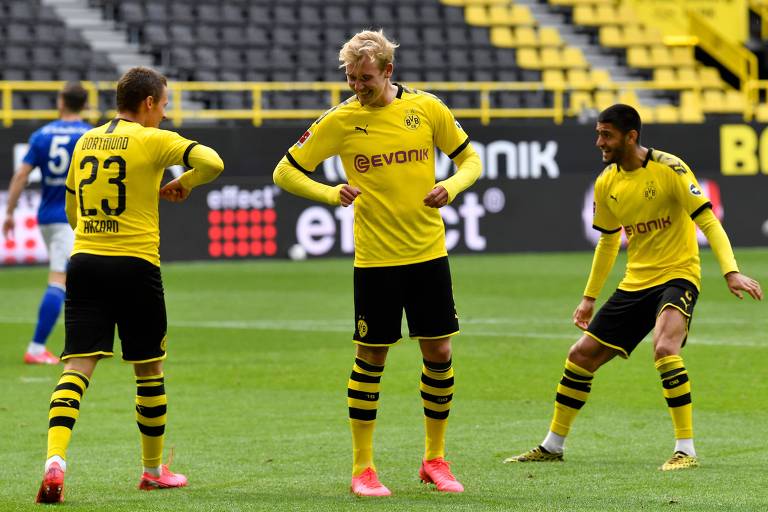 O atacante belga Thorgan Hazard (à esq.) comemora com Julian Brandt (centro), sem abraços, o terceiro gol do Borussia Dortmund sobre o Schalke 04 