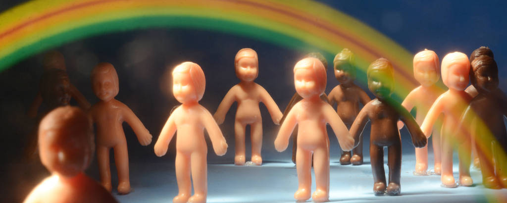 Foto ilustração mostra bonecos sob o arco-íris, símbolo do movimento LGBTI