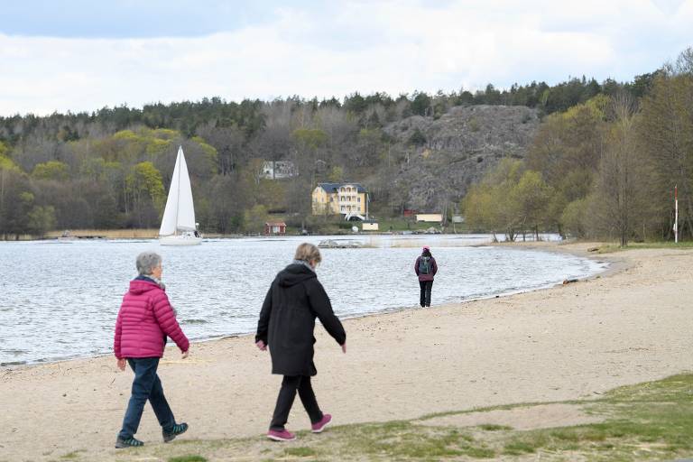Pessoas caminham pela orla do lago Malaren, em Satra, perto de Estocolmo