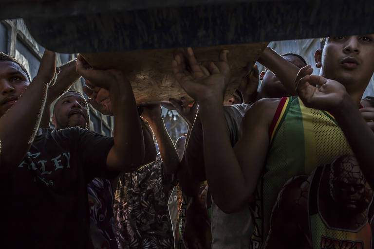 Amigos e familiares no enterro de adolescente que foi morto em tiroteio enquanto esperava por um corte de cabelo