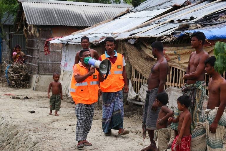 Voluntário de programa de preparação para chegada de ciclones usa megafone para pedir a habitantes de Khulna evacuem suas casas