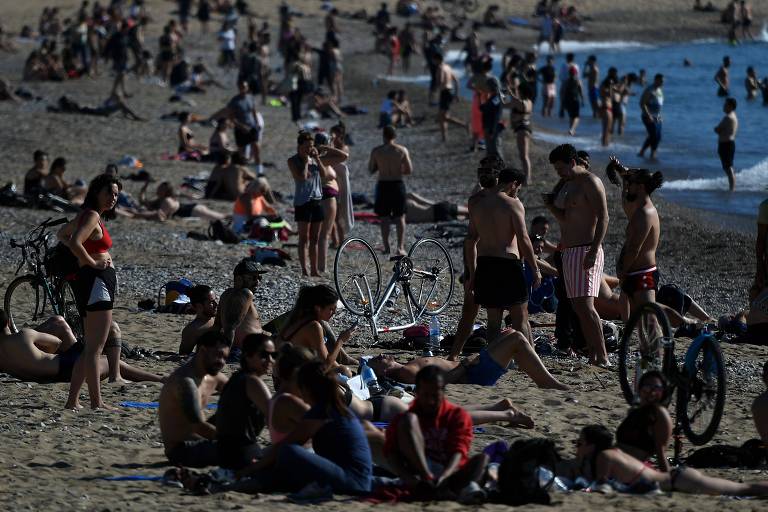 Praia de Barceloneta, em Barcelona, fica cheia de frequentadores após relaxamento parcial das medidas de combate ao novo coronavírus