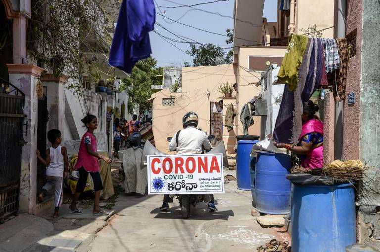 Agricultor trafega por aldeias de Telangana para conscientizar sobre o coronavírus, na Índia
