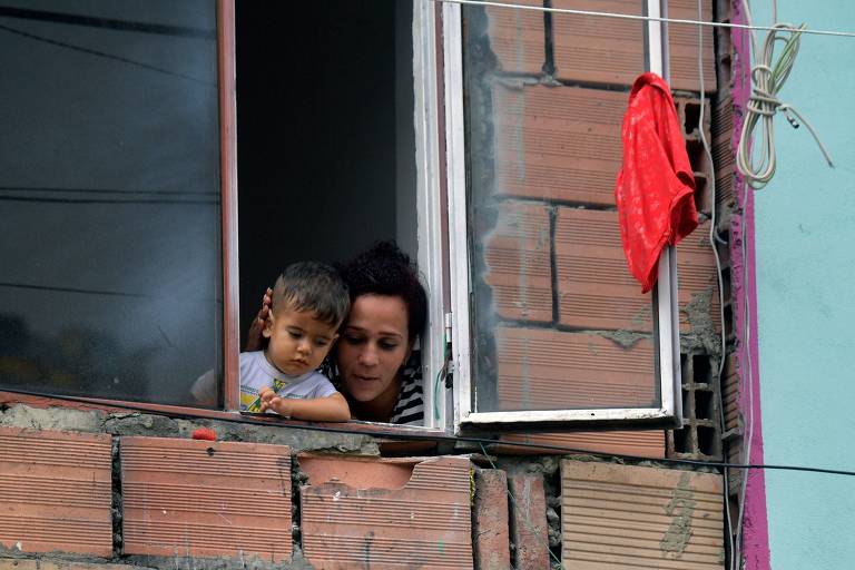 Moradores de Bogotá com panos vermelhos pendurados nas janelas de suas casas para pedir ajuda do governo em meio à pandemia de coronavírus